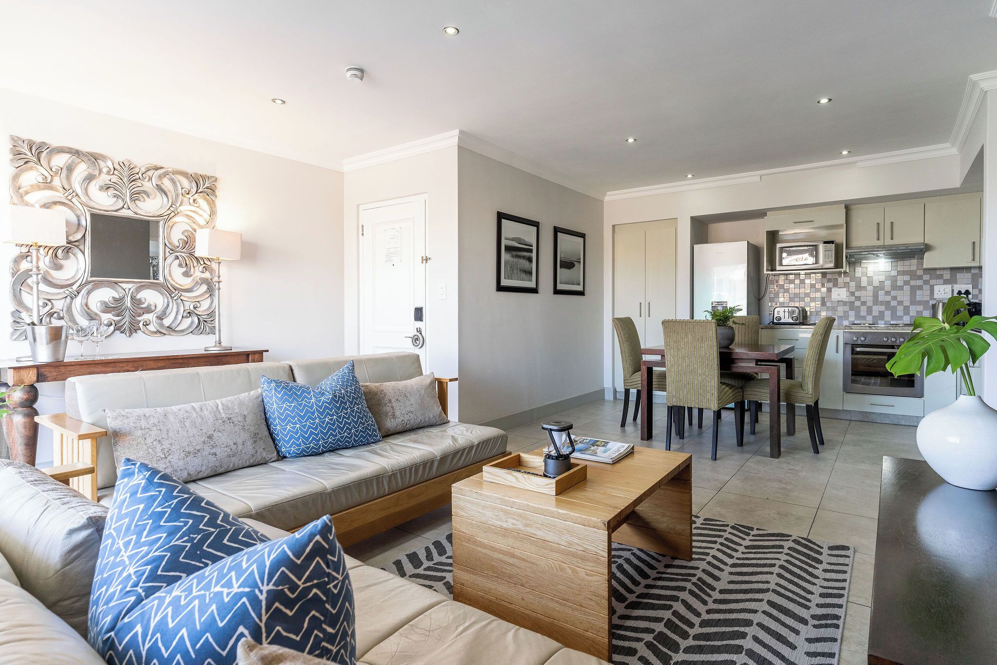 A modern living room with a sofa, coffee table, and dining area.