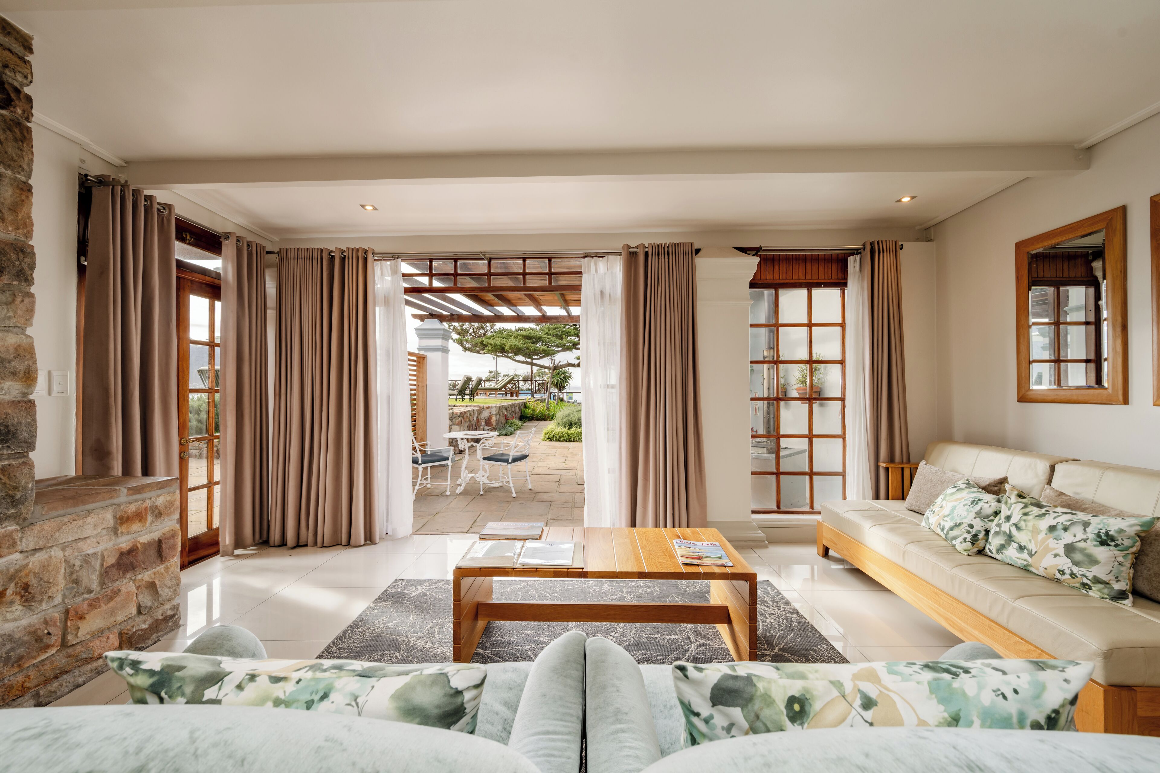 A spacious living room with a sofa, a coffee table, and a view of an outdoor patio area.