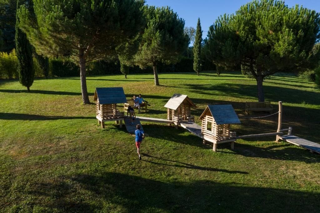A playground with wooden play structures and a clear sky.