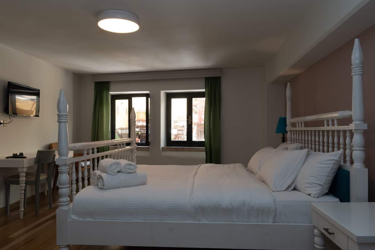 A hotel room with a bed, a desk, and a chair.