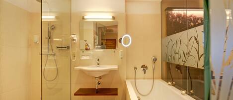 A modern bathroom with a glass-enclosed shower, a sink, and a bathtub.