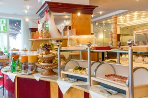 Disposição de buffet com diversos alimentos e bebidas.