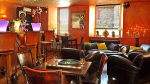 A cozy bar area with leather chairs, a dartboard, and a bar counter.