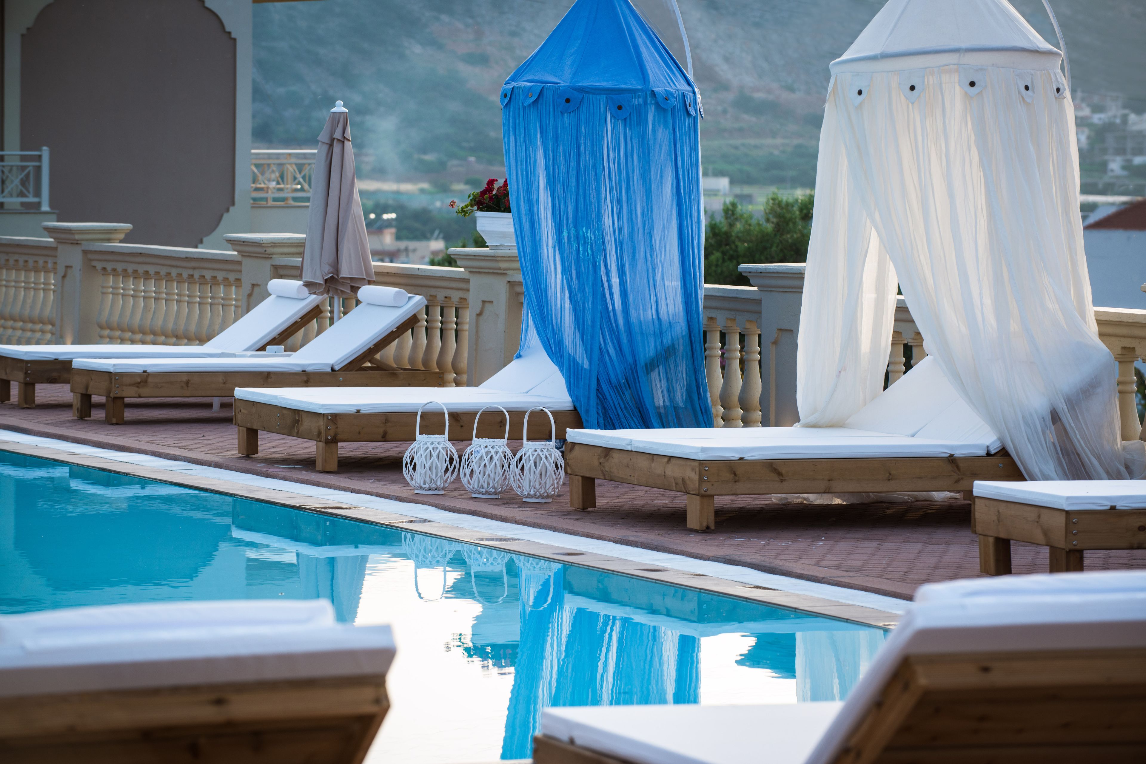 A pool area with lounge chairs and a canopy structure.