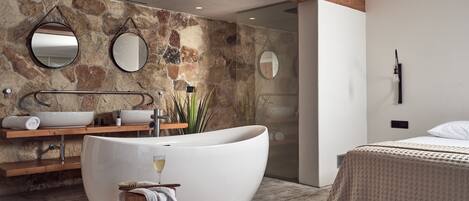 A modern bathroom with a freestanding bathtub, a wooden vanity, and a large mirror.