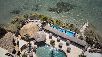 Relax by the pool or unwind in the hot tub, surrounded by sun loungers and thatched umbrellas.