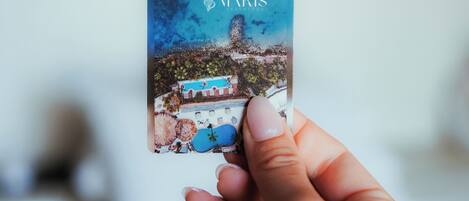 A hand holding a book titled 'GLORIA MARIS' with a coastal scene on the cover.