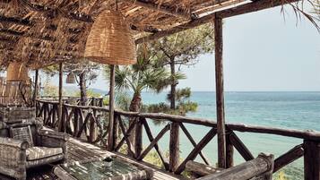 A wooden deck with wicker furniture overlooking a body of water.