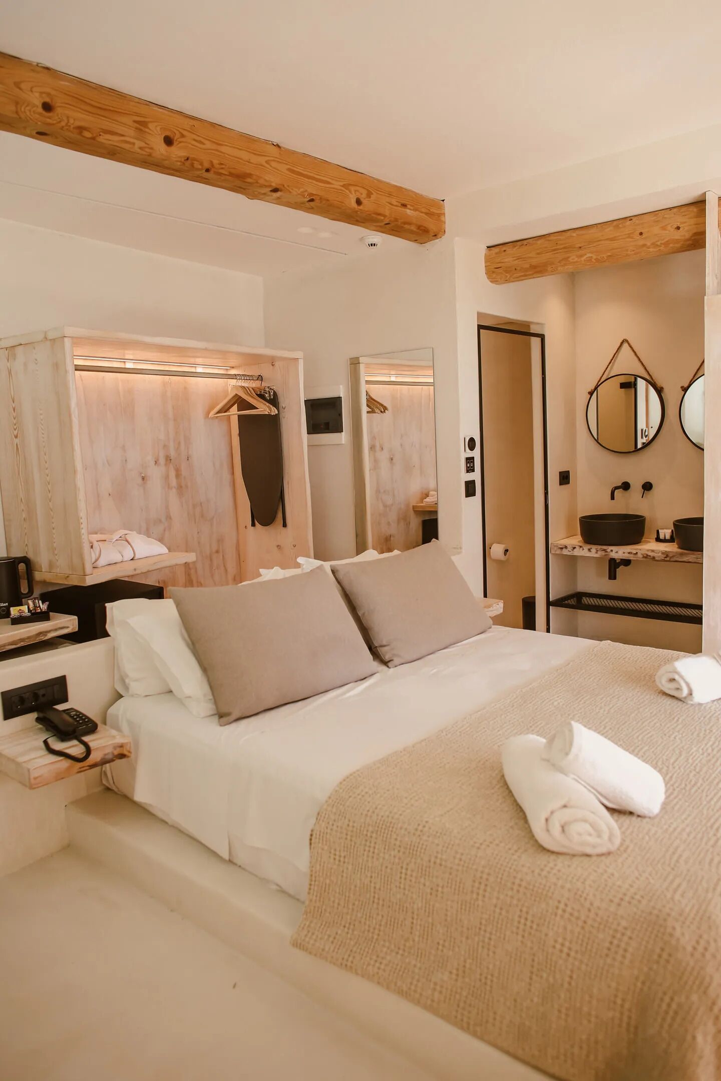 A bedroom with a bed, bedside table, and a wooden headboard.