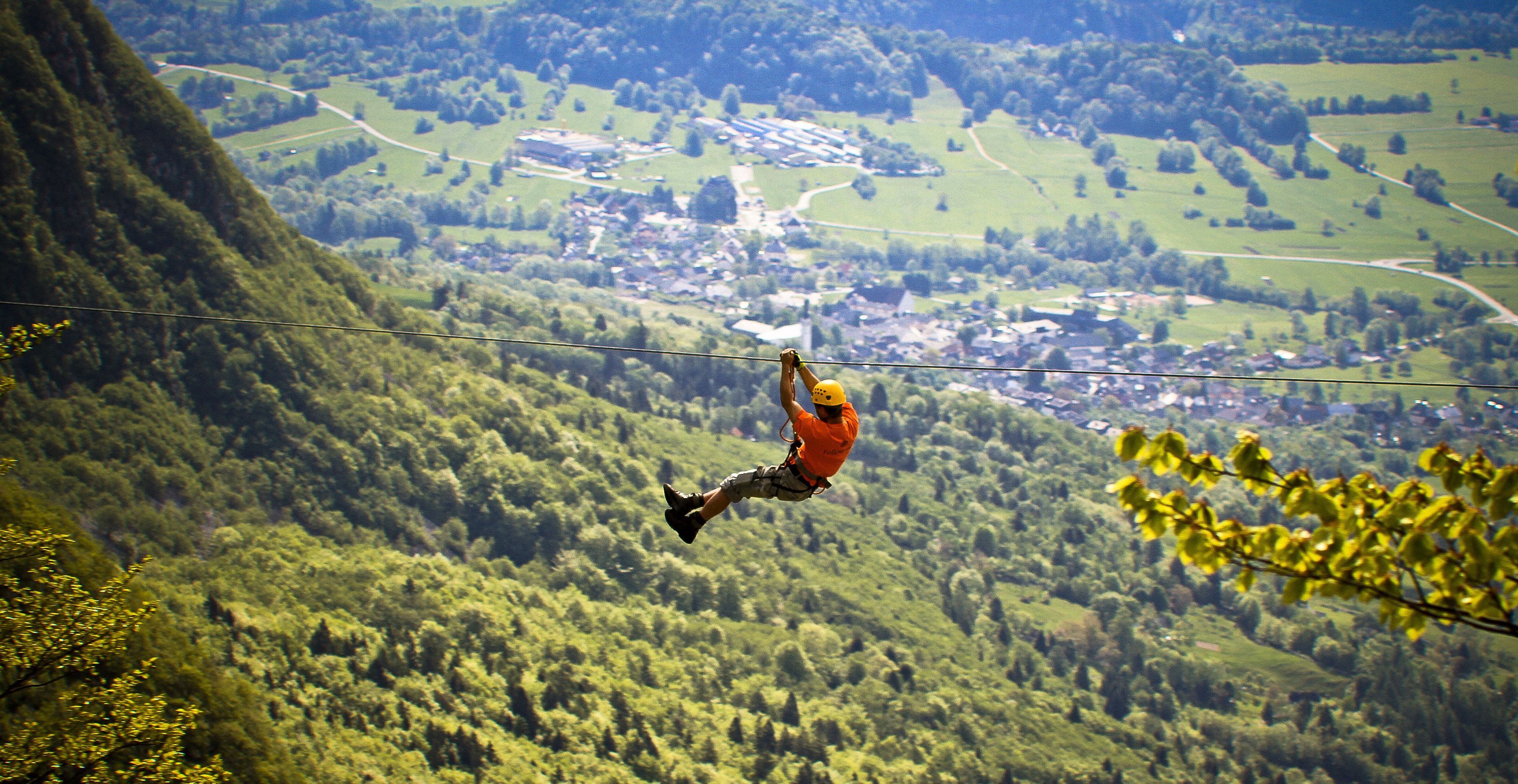 Une personne pratiquant le saut à l'élastique avec un paysage montagneux en arrière-plan.