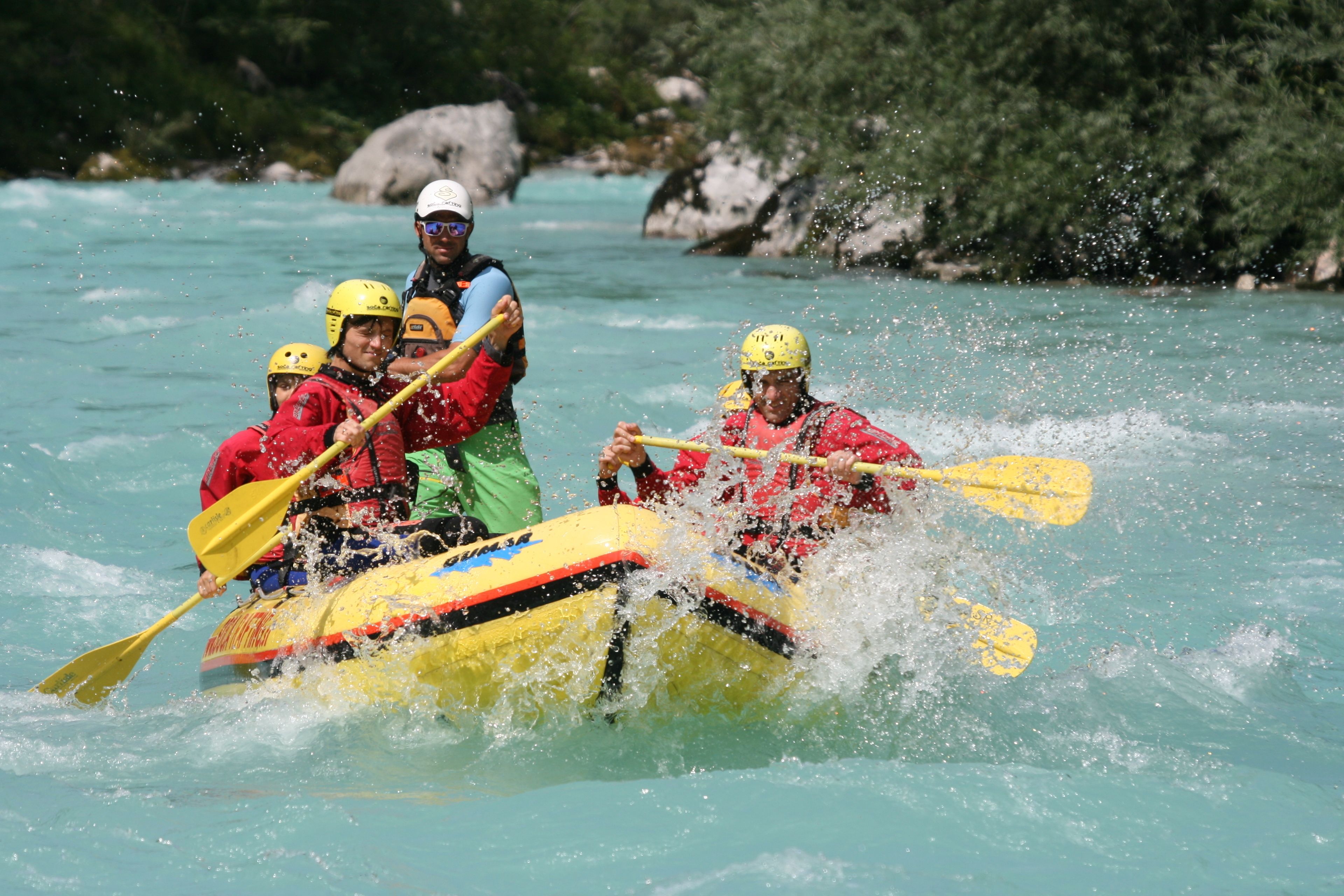 A group of people in a yellow raft navigating a river.