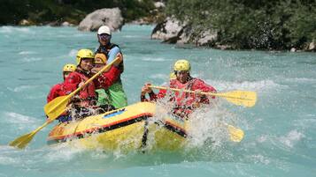 A group of people in a yellow raft navigating a river.