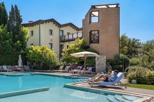 Una piscina al aire libre de temporada, sombrillas