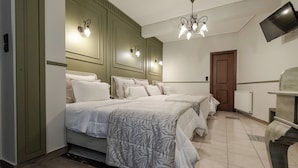Una habitación de hotel con una cama grande, un escritorio, una silla, un televisor y una puerta.