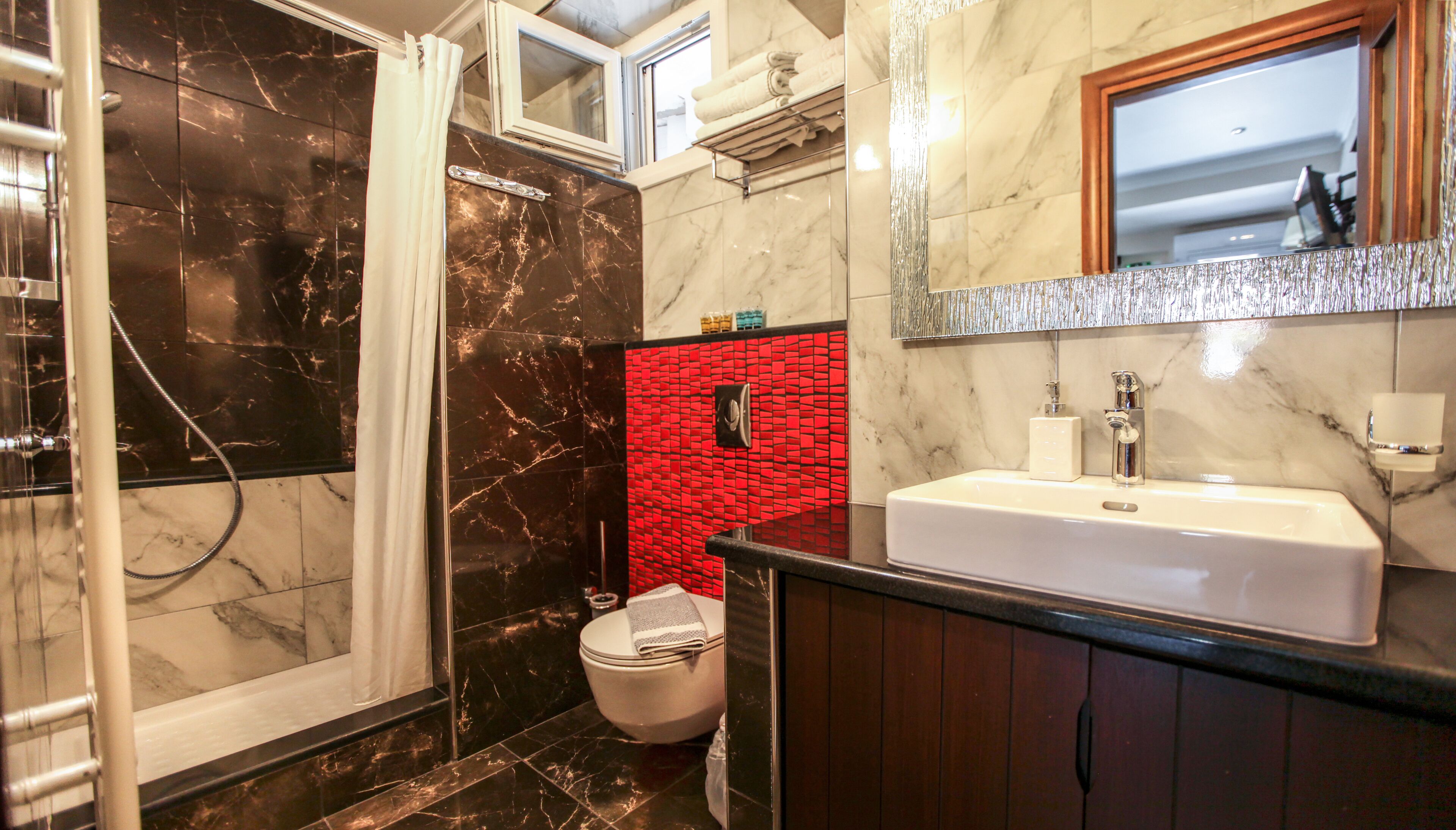 A bathroom with a shower, toilet, and sink.