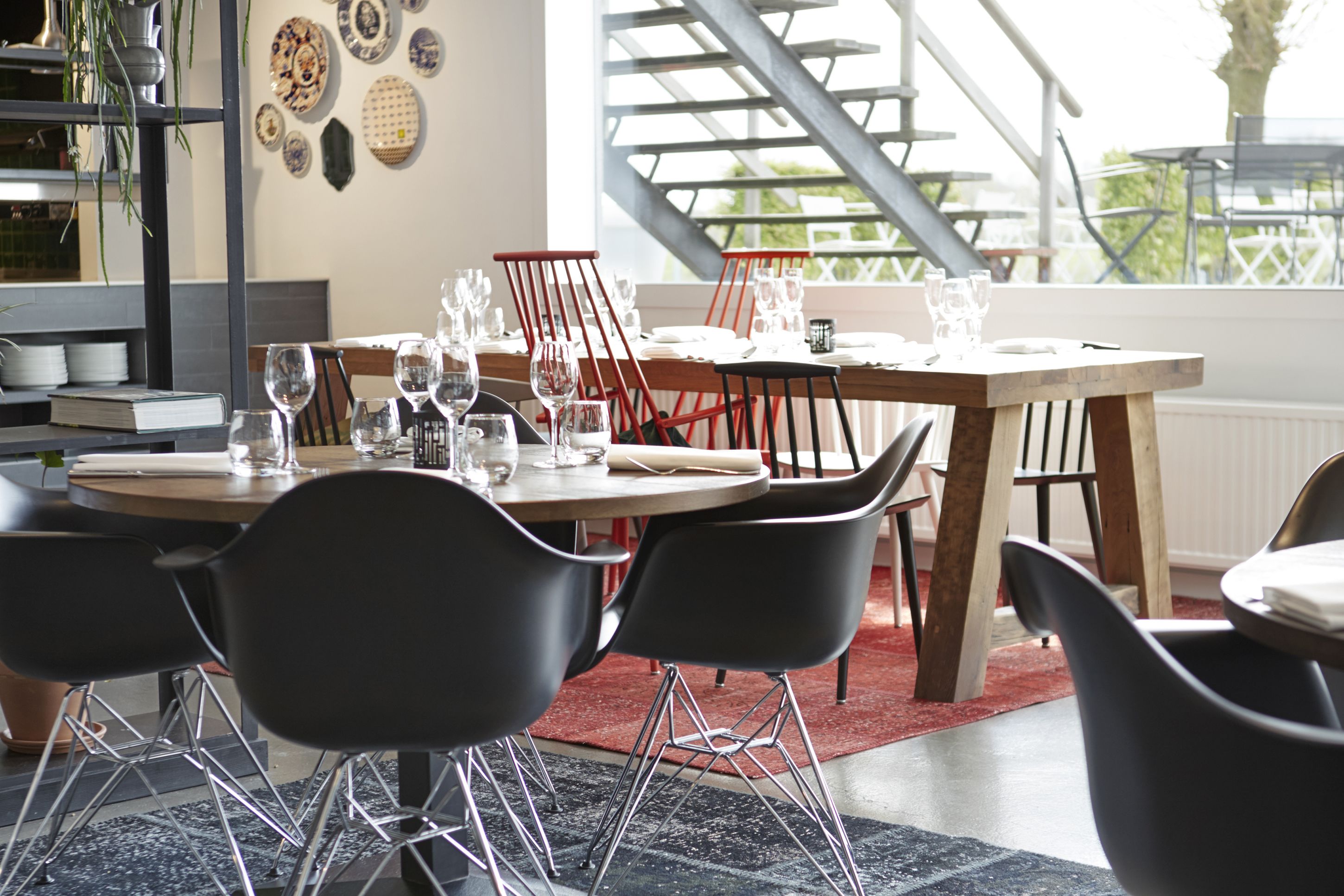 A dining area with a wooden table set for four, surrounded by black chairs.