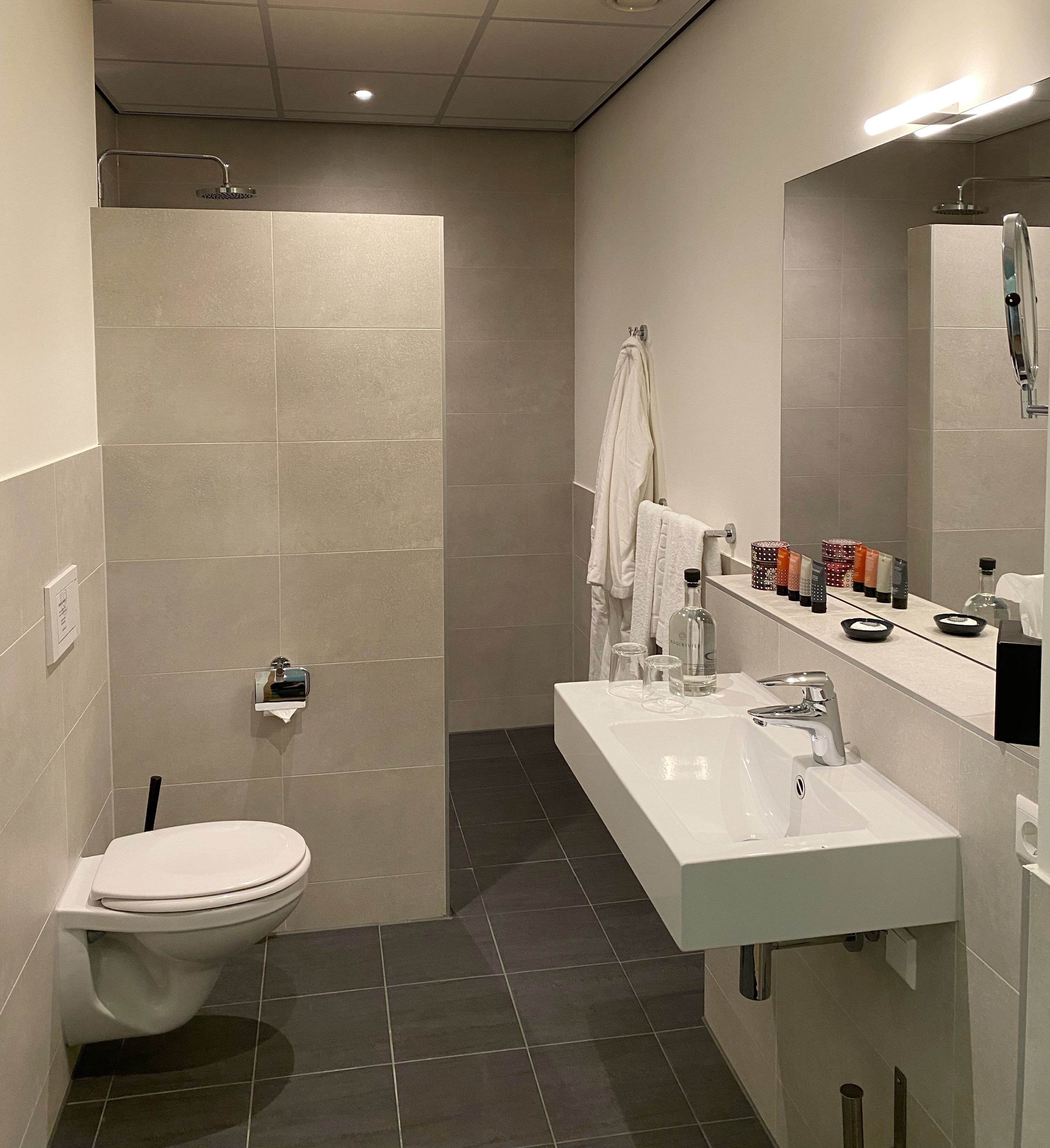 Une salle de bain moderne équipée de toilettes, d’une douche et d’un lavabo.