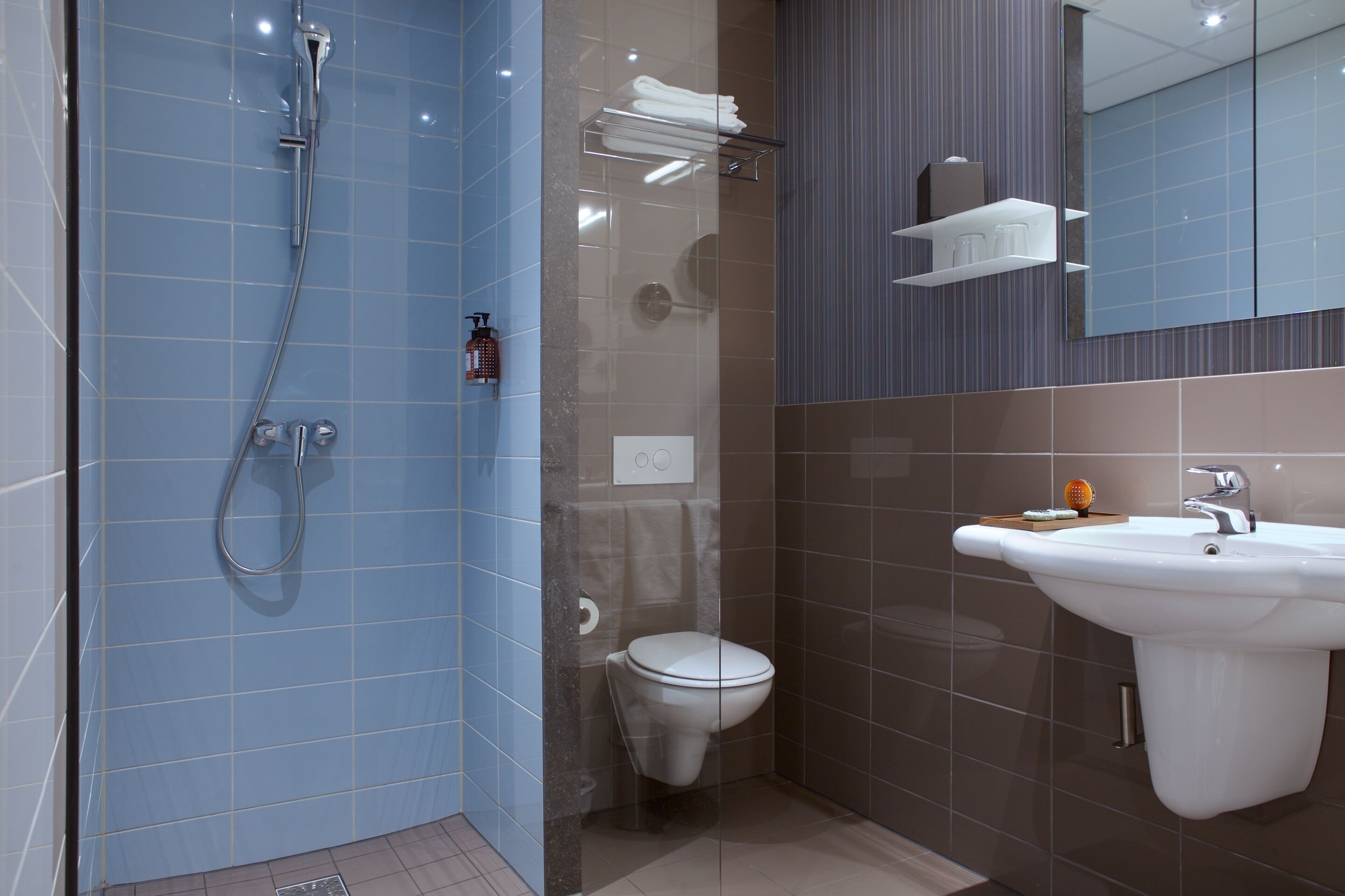 A modern bathroom with a shower, toilet, and sink.