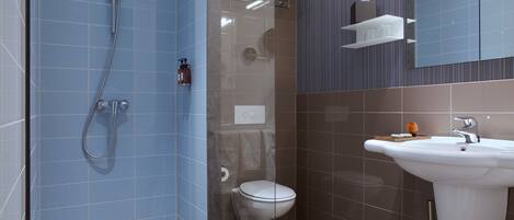 A modern bathroom with a shower, toilet, and sink.