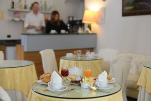 Un'ambientazione da colazione con tavoli, sedie e un bancone sullo sfondo.