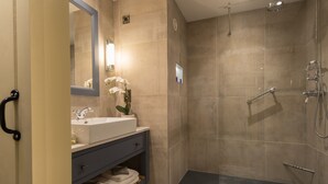 A modern bathroom with a shower, sink, and toilet.