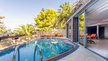 Relax by the clear pool surrounded by lush greenery and lounge in style.