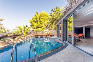 Una piscina al aire libre, sillones reclinables de piscina