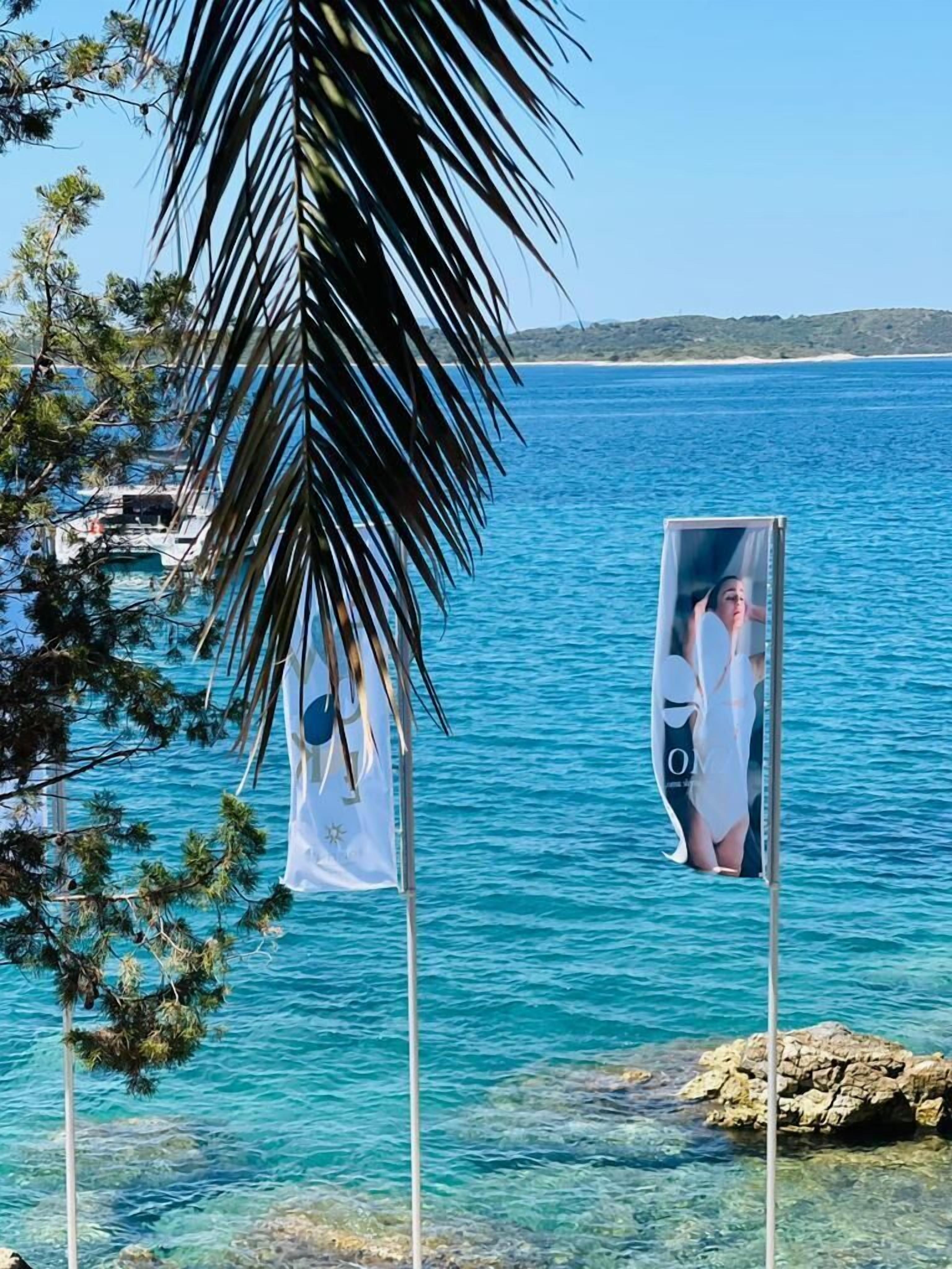 Vista despejada de una zona costera con un asta de bandera ondeando un estandarte.