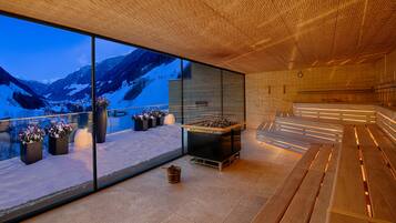 Ein modernes Interieur mit großen Fenstern, die einen Blick auf schneebedeckte Berge freigibt.