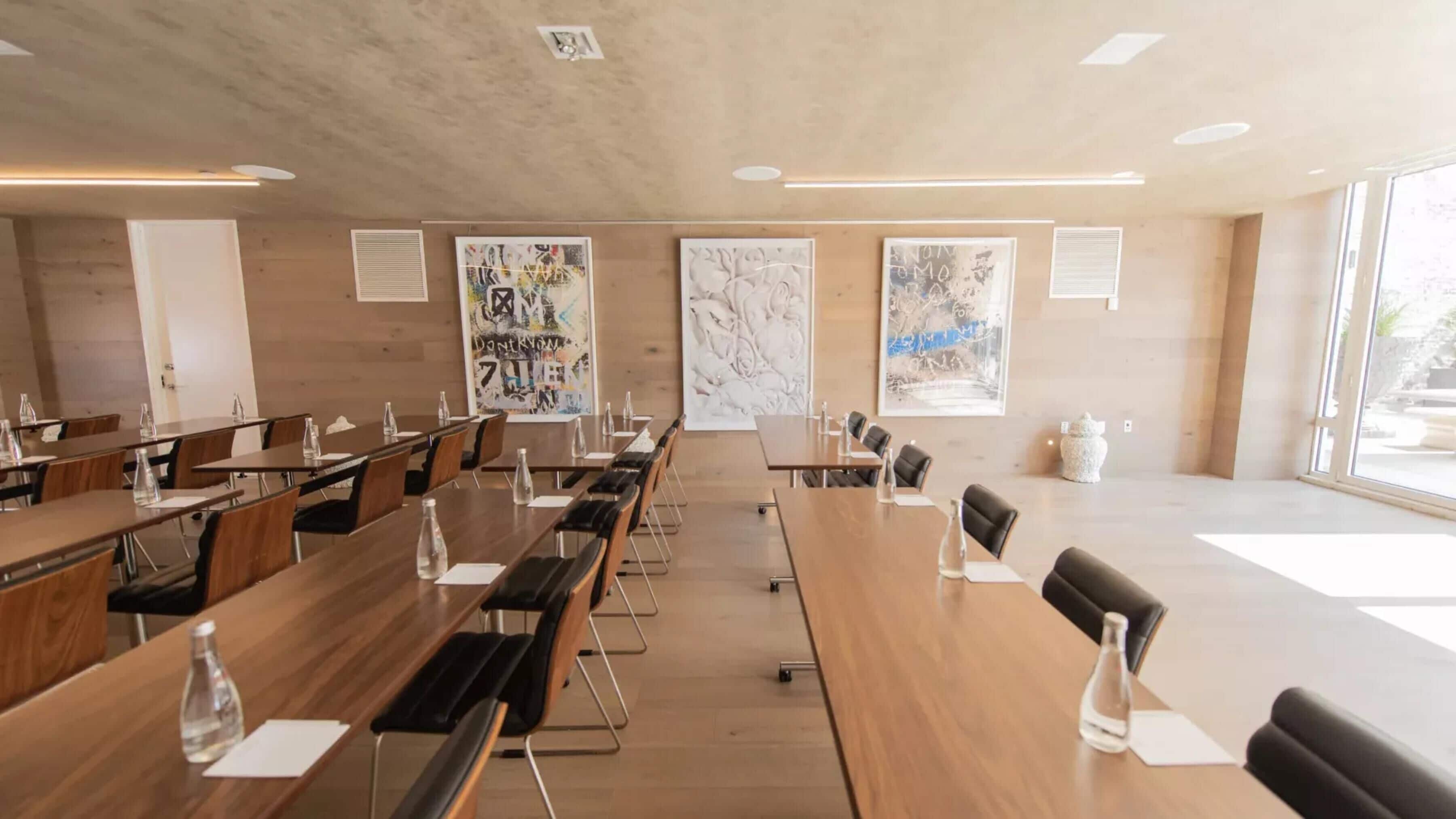 A conference room with long tables, chairs, and water bottles.