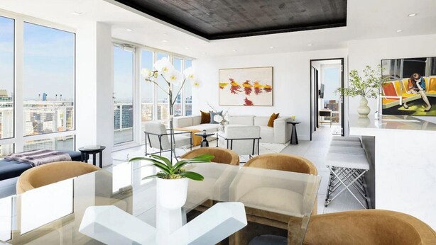 A modern living room with a glass dining table, white sofas, and a city view.