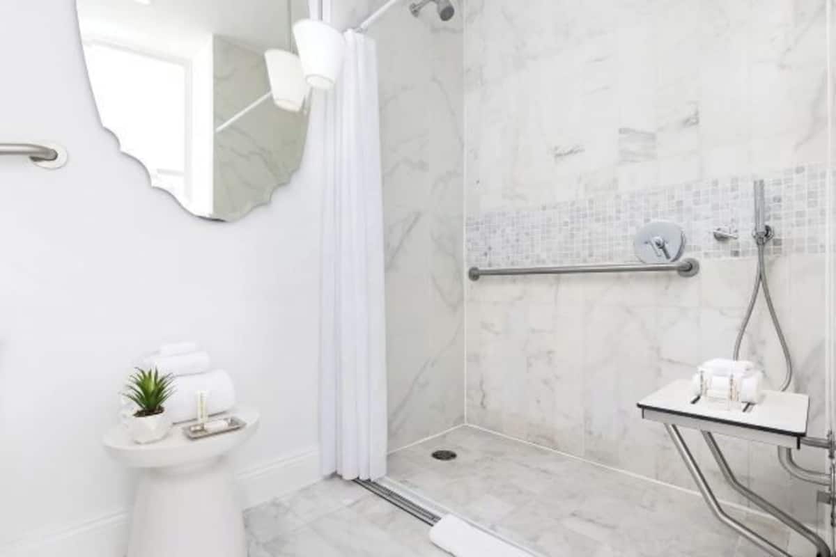 Shower, designer toiletries, hair dryer, towels
