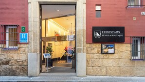The entrance to Eurostars Sevilla Boutique, featuring a stone facade, a glass entrance, and a signboard. - Eurostars Sevilla Boutique (Seville)
