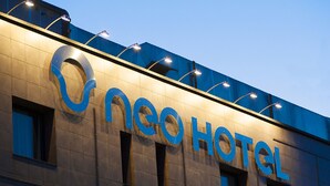 Un edificio de hotel con un llamativo letrero que dice 'neo HOTEL'.