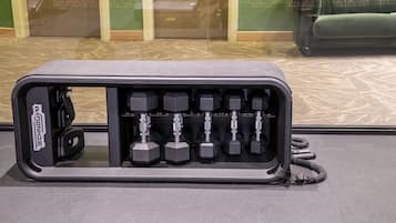 A compact, gray storage unit with multiple compartments, likely for storing gym equipment.