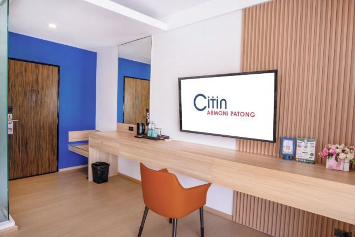 A reception desk with a framed sign, a mirror, a wooden counter, and a chair.