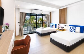 A hotel room with a bed, a desk, a chair, a TV, and a balcony with a view of palm trees and buildings.