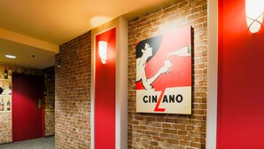 A corridor with a brick wall, a red door, and a poster advertising 'CINZANO'. - KOKO STAY Chitose (Chitose)
