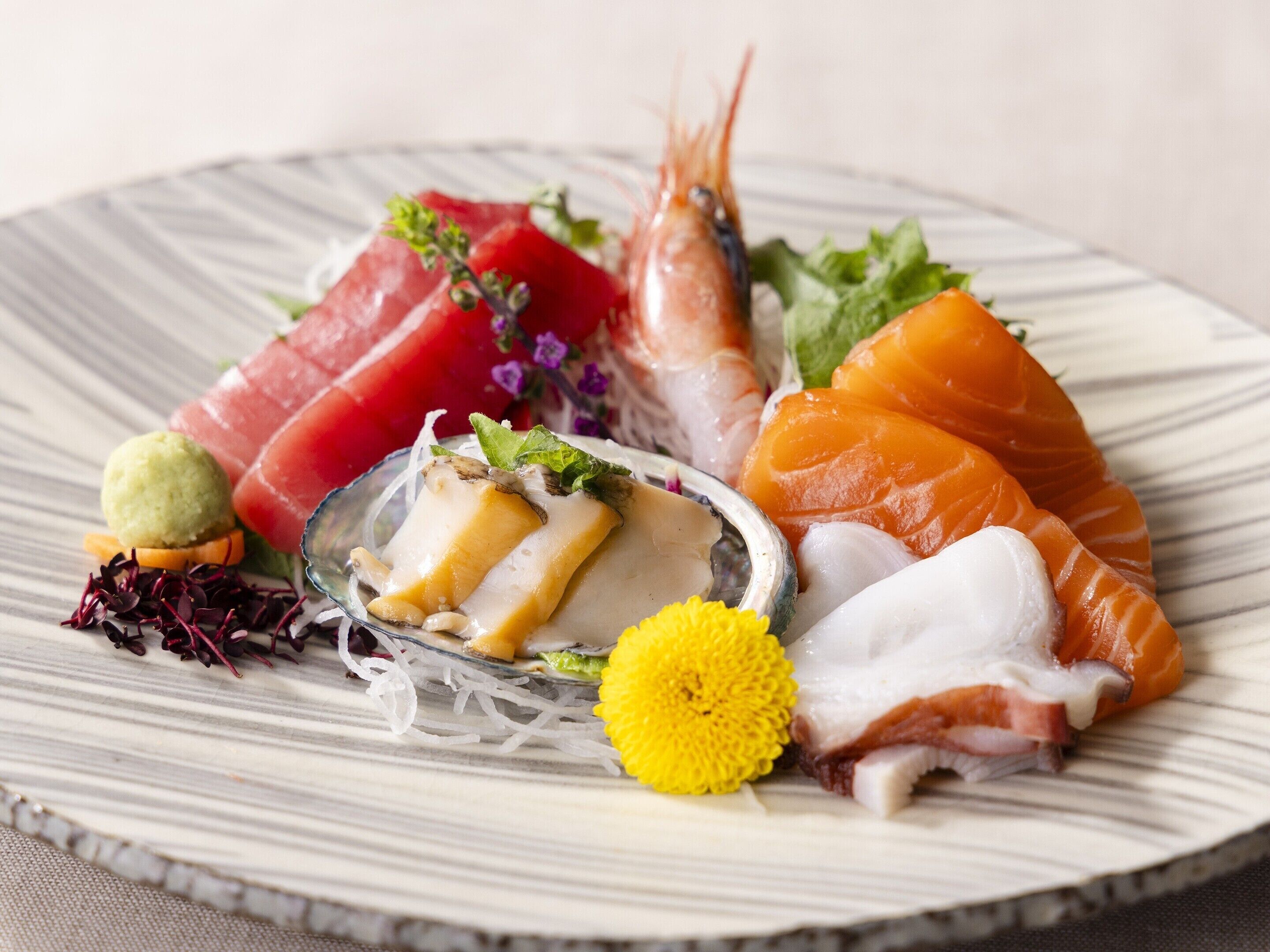 A plate of sushi with various types of fish and garnishes.