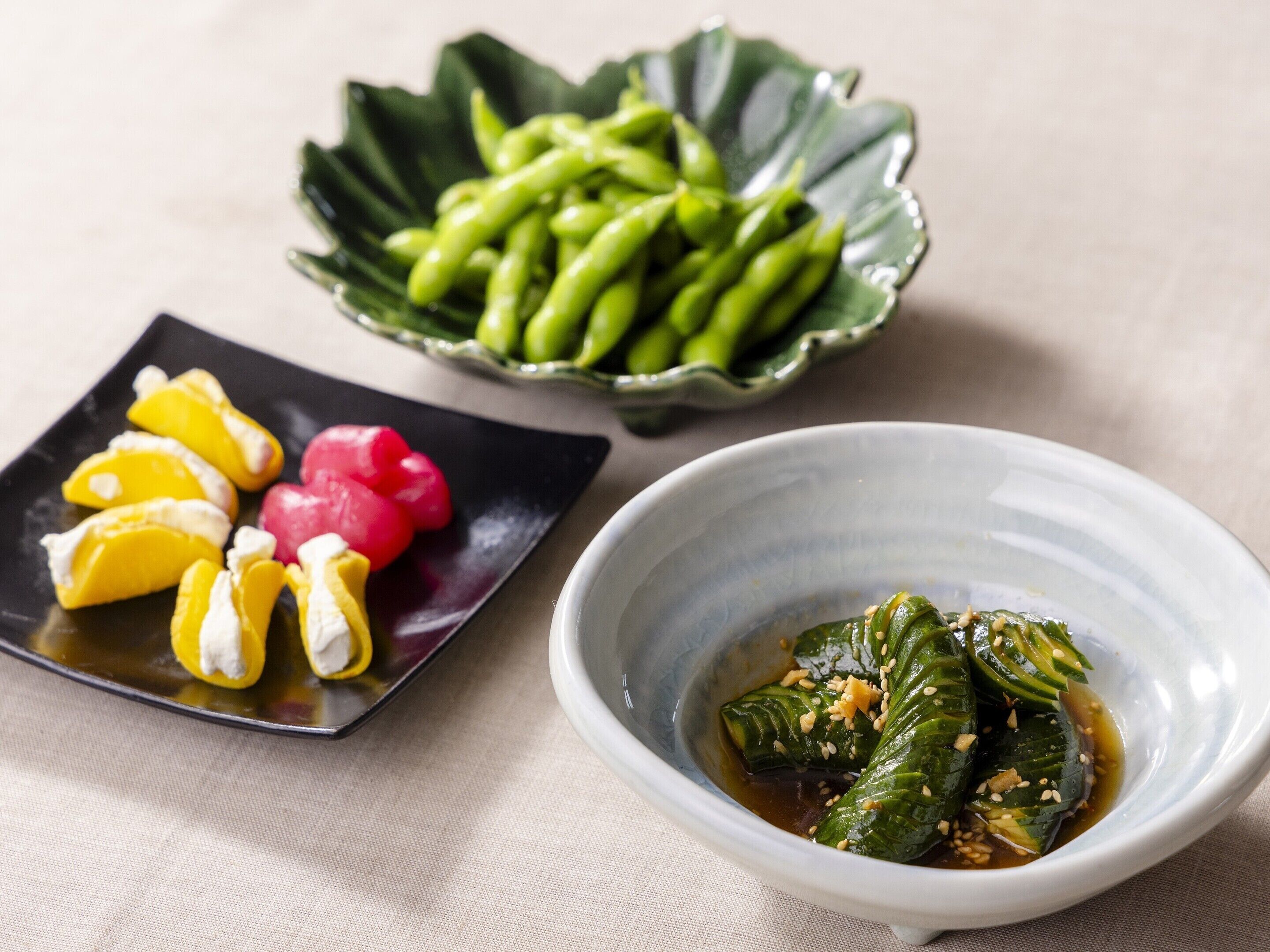 A plate with pickled vegetables and a bowl of soy sauce with vegetables.
