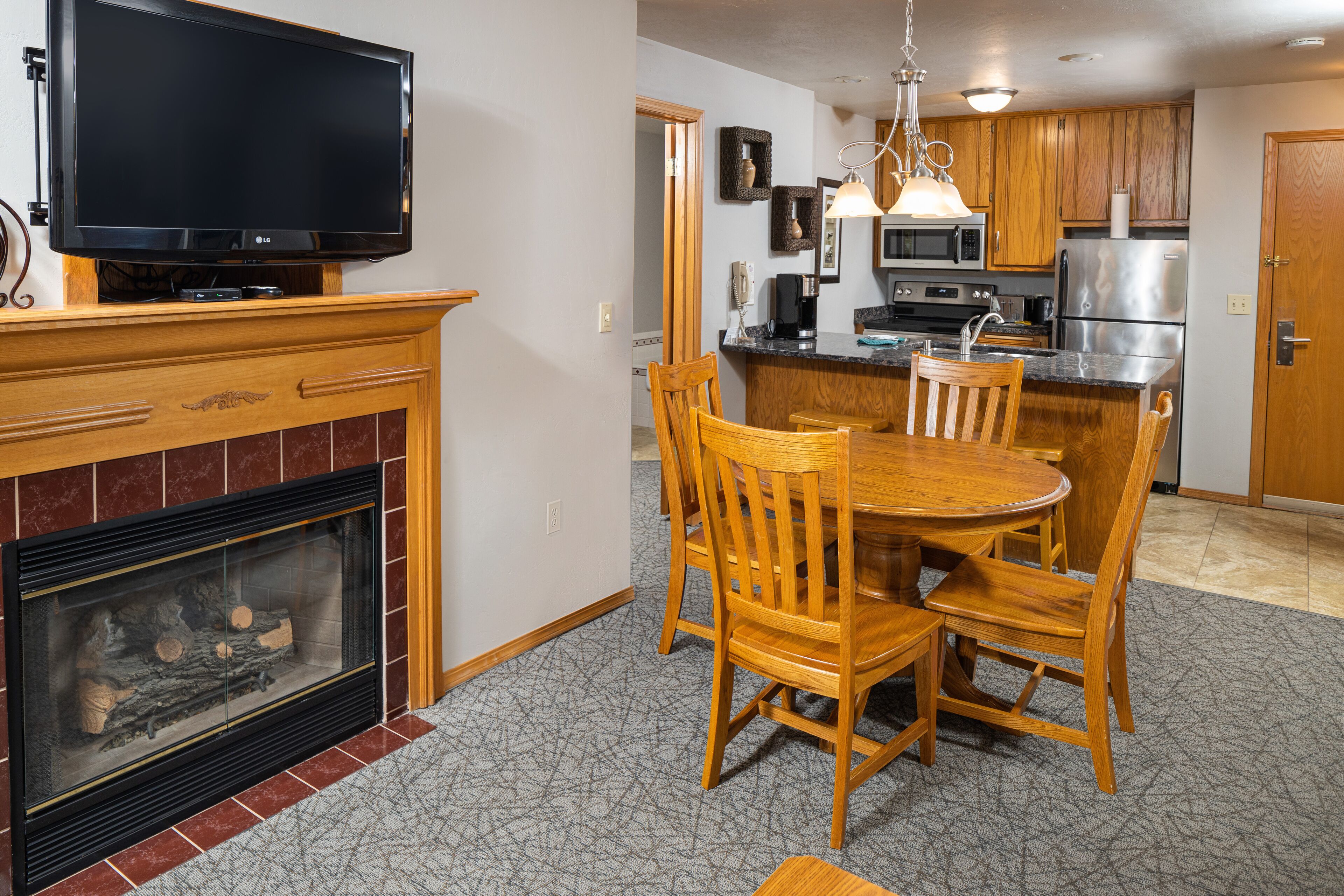 A modern kitchen with wooden cabinets, a built-in microwave, and a stainless steel refrigerator.