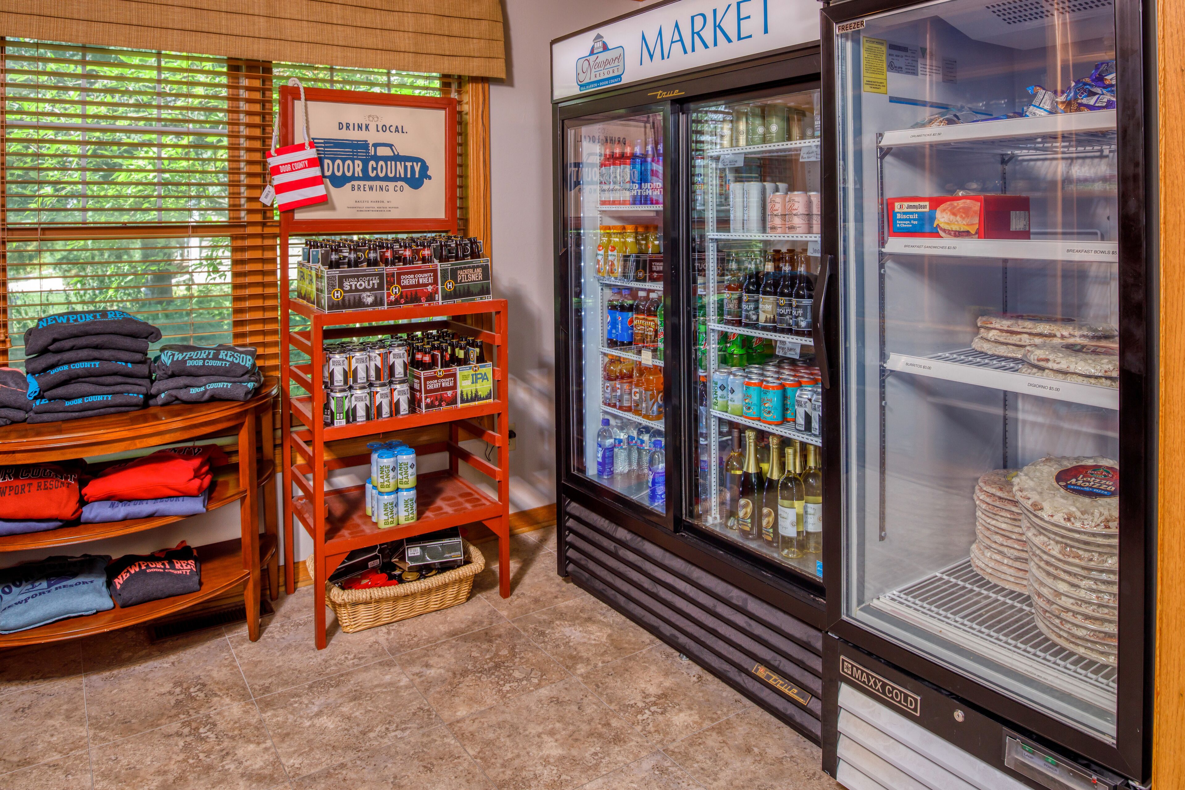 A store with a refrigerated display case, shelves stocked with beverages, and a sign indicating a local brewery.