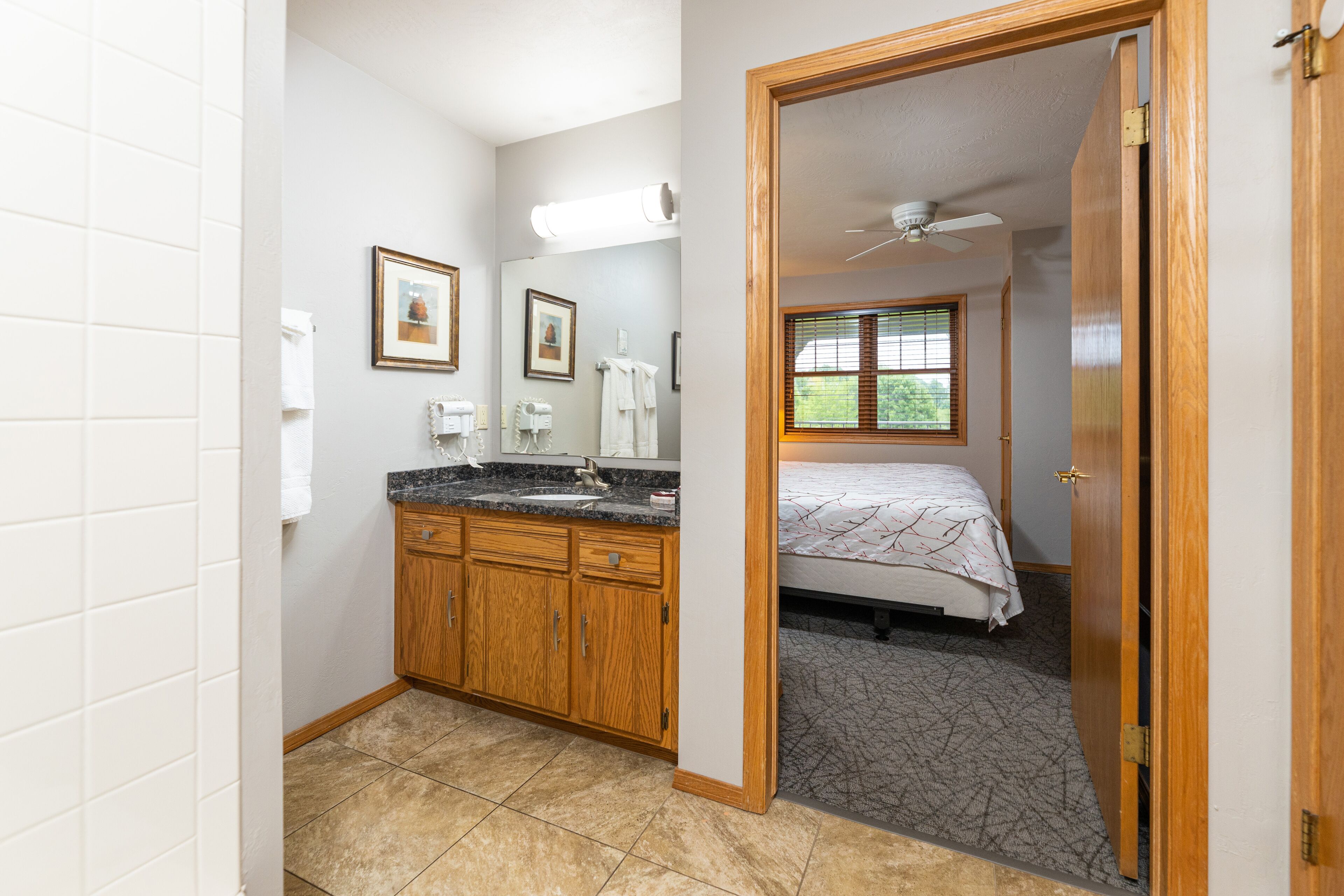 A bathroom with a vanity, sink, and framed pictures on the wall.