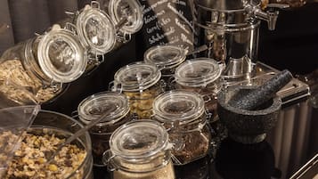 Forskellige glasbeholdere med madvarer, en kaffemaskine og en morter og støder.