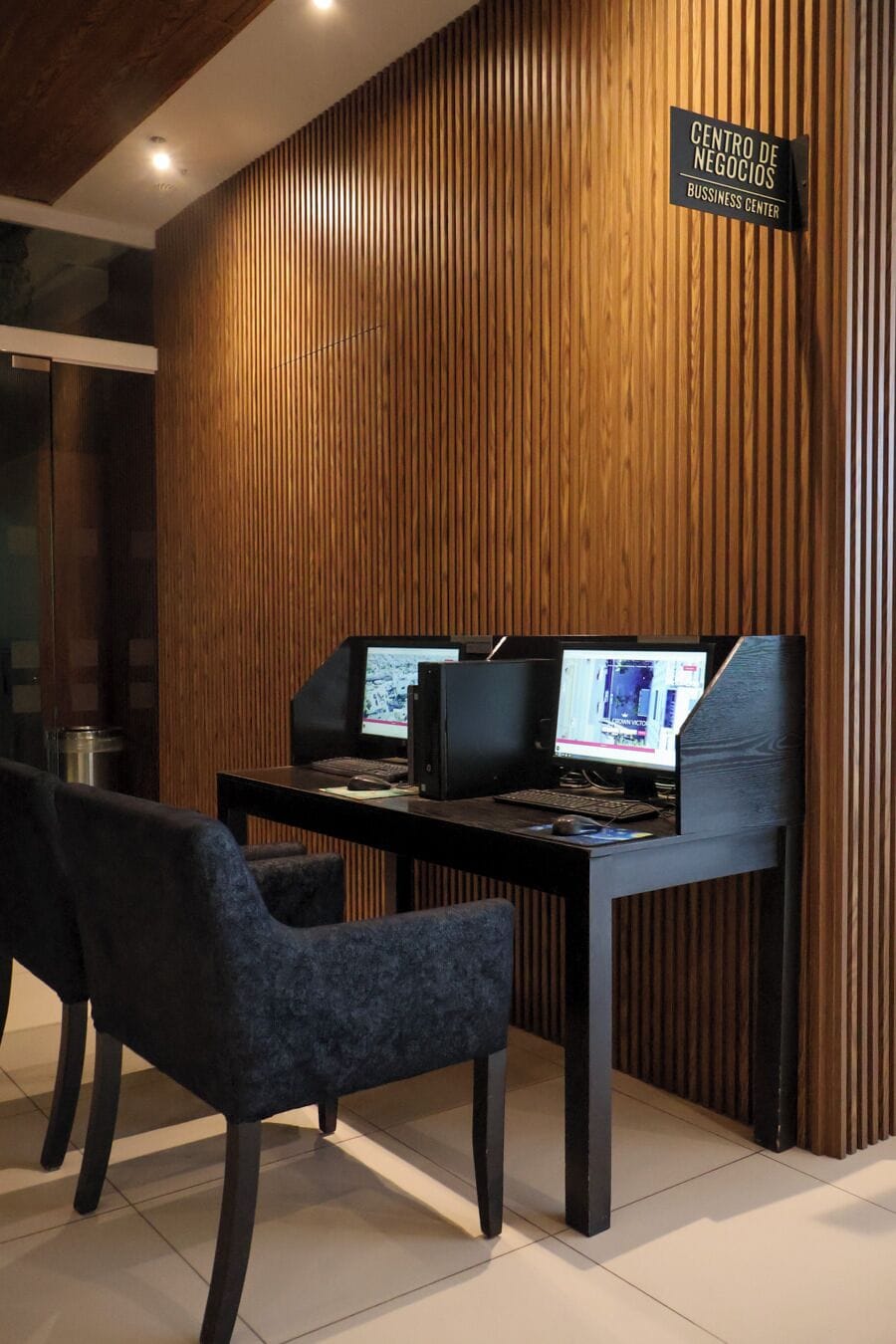 Ein Businesscenter mit zwei Computern, einem Hinweisschild und einem modernen Interieur.
