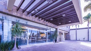 Un bâtiment moderne doté d’une entrée en verre, d’un revêtement de sol en pierre et d’un patio couvert.