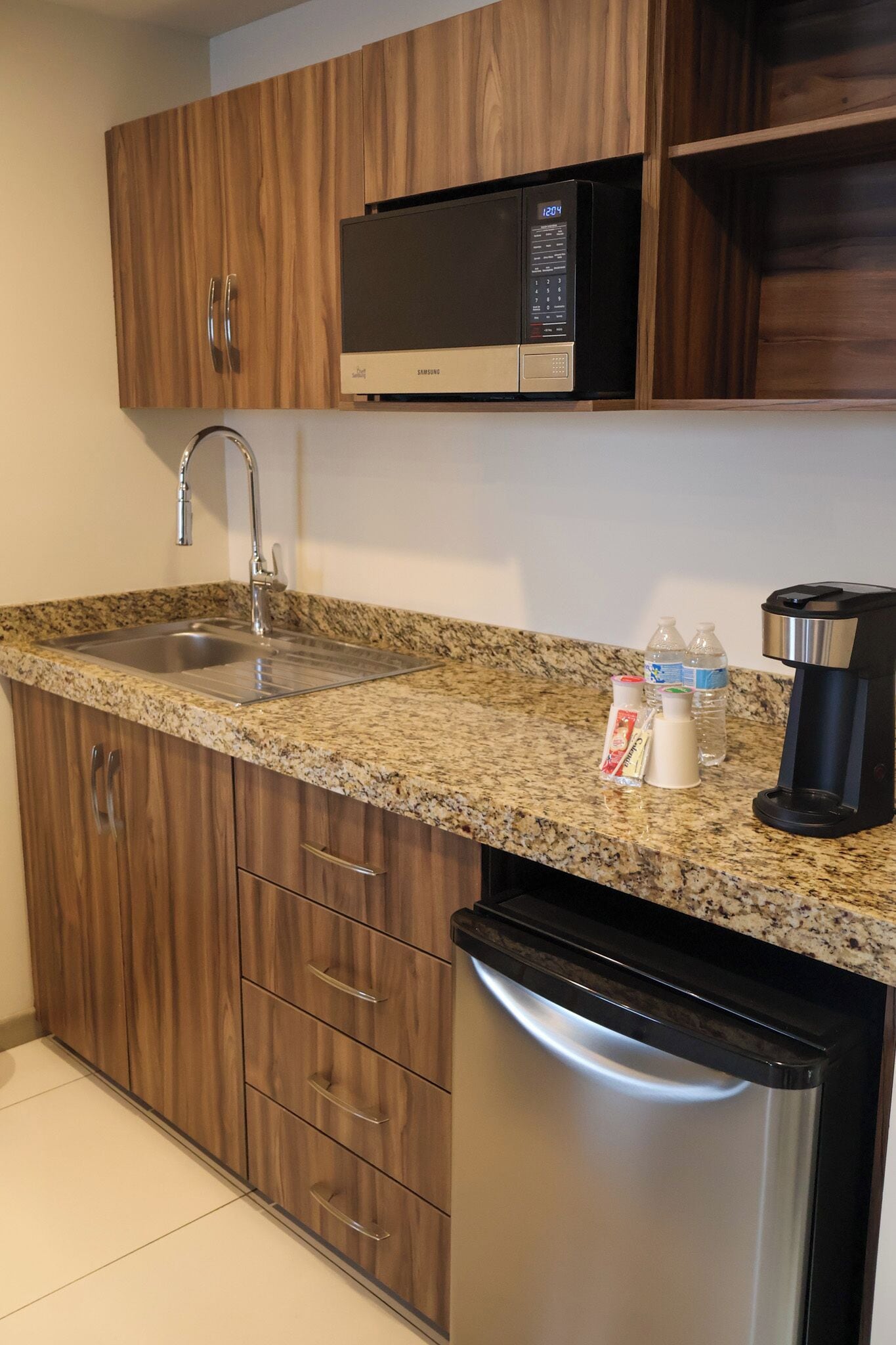 A kitchen with a granite countertop, stainless steel appliances, and wooden cabinets.