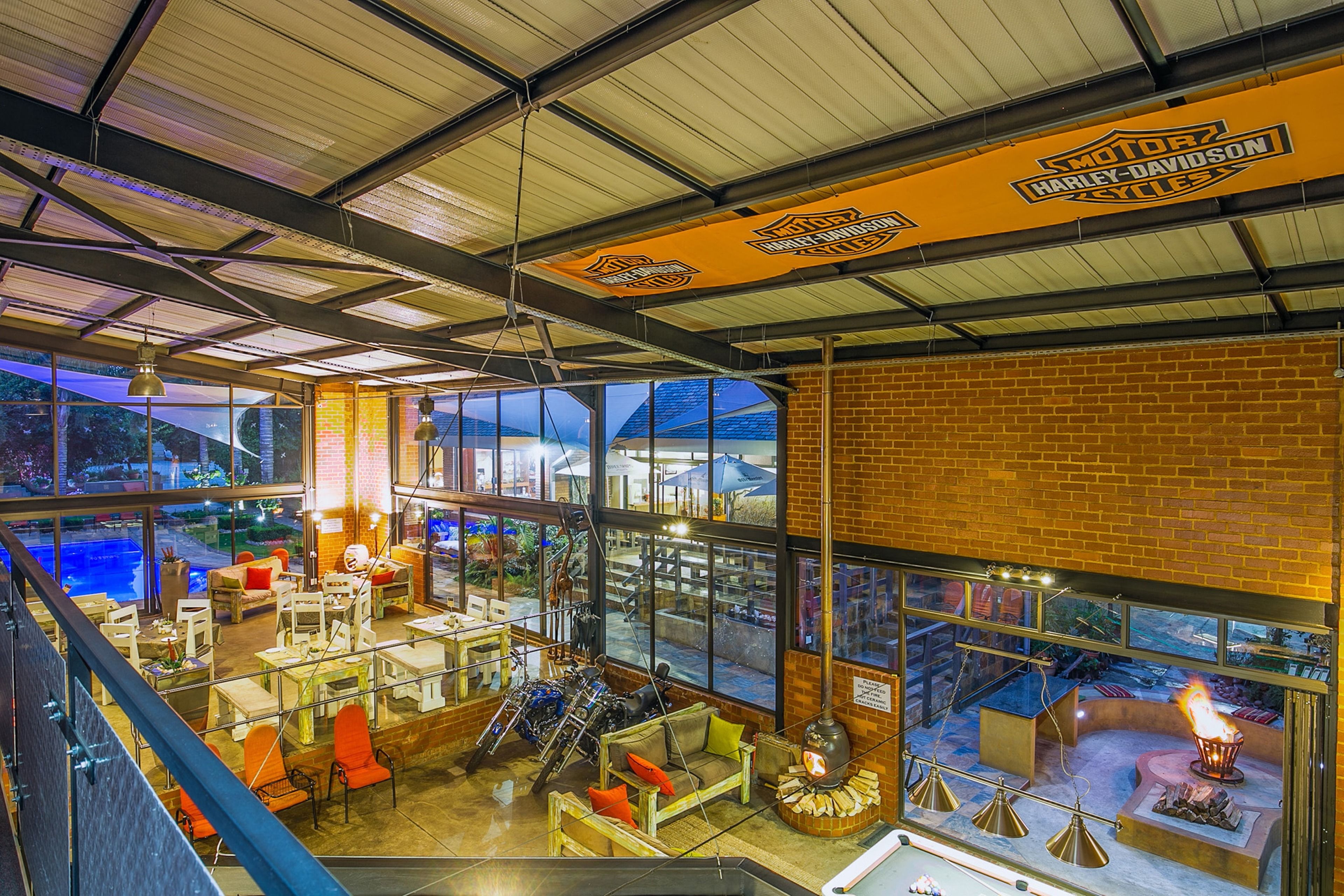 A restaurant with a Harley-Davidson sign, outdoor seating, and a fireplace.
