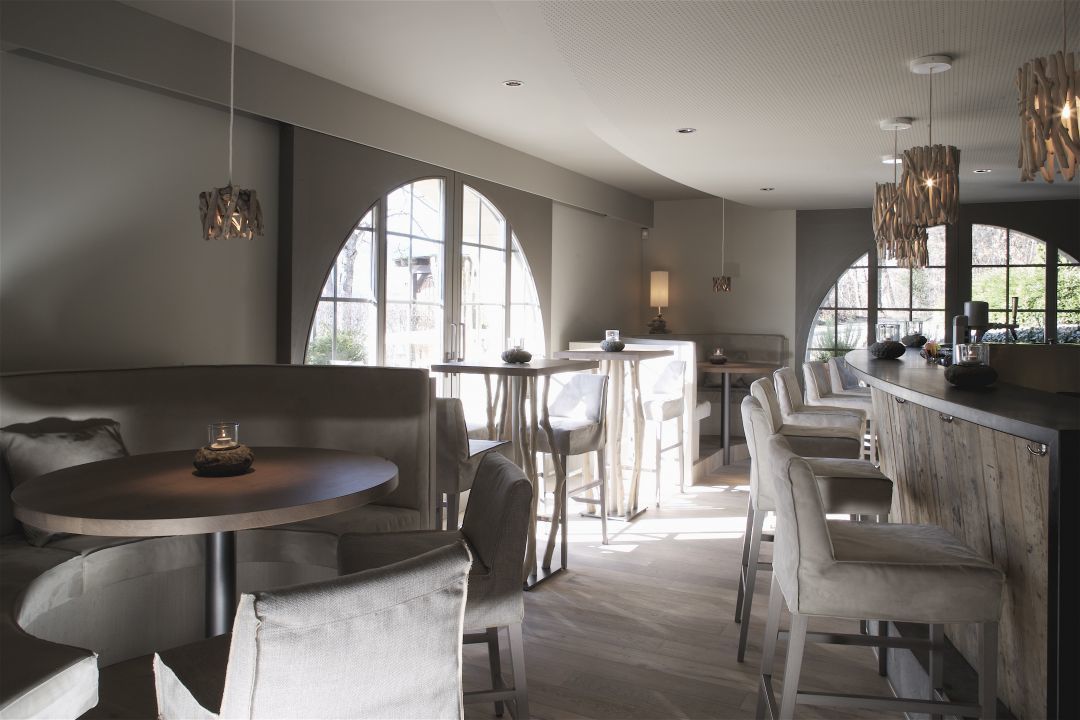 A modern interior with a round table, bar area, and seating.