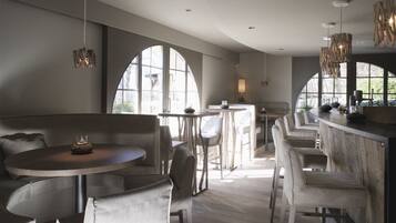 A modern interior with a round table, bar area, and seating.